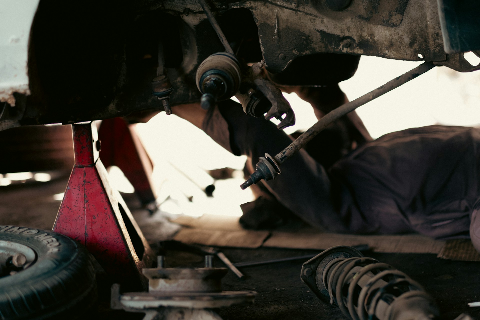 Technician performing undercarriage drivetrain inspection